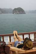 A canadiana Jeanne num barco turístico apreciando a paisagem em Halong, Vietname