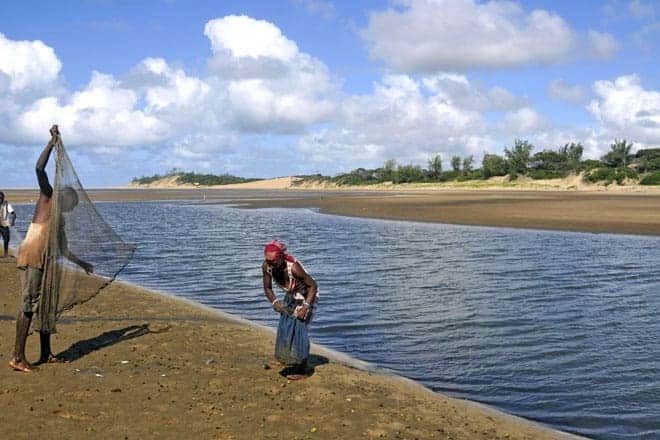 Um pescador lança a rede na praia do Zongoene