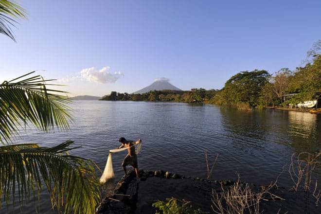 Ao fim da tarde, com o vulcão Concepción ao fundo, um jovem pescador lança a rede no lago Cocibolca
