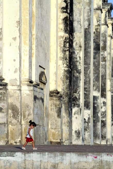 Uma criança passa defronte da Catedral de León, Nicarágua