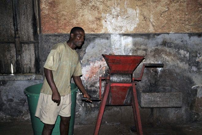 Miguel demonstra o funcionamento de uma máquina utilizada no processamento do cacau, São Tomé
