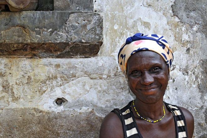 A simpatia são-tomense bem patente no sorriso tímido de uma moradora da Água Izé à porta de sua casa