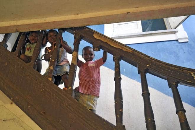 Miúdos espreitam o visitante na escadaria do antigo hospital da roça Água Izé